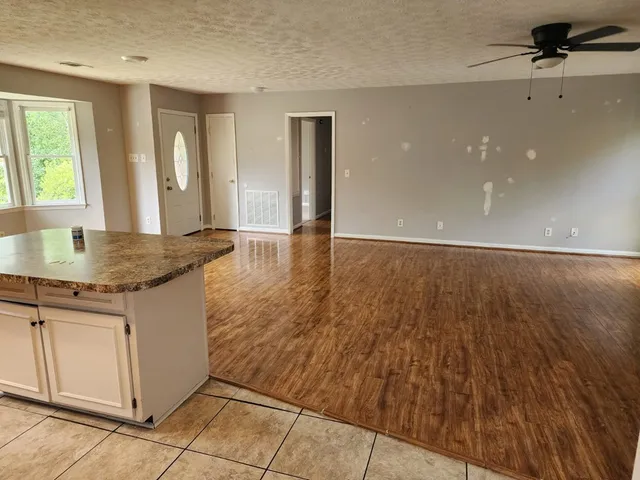 an empty room with wooden floor and cabinet