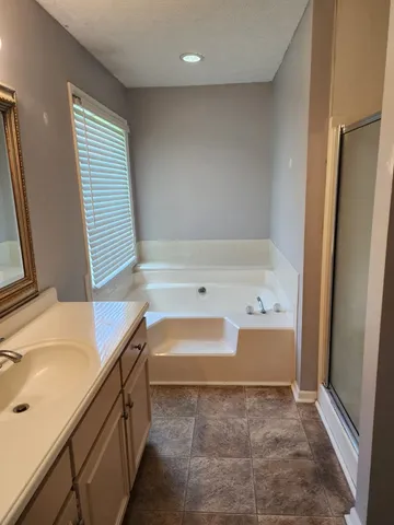 a bathroom with a tub sink and a shower
