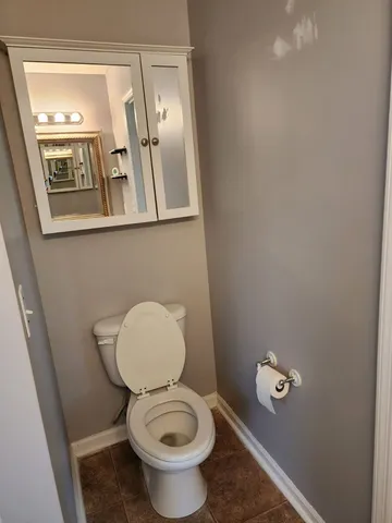 a bathroom with a toilet and a mirror