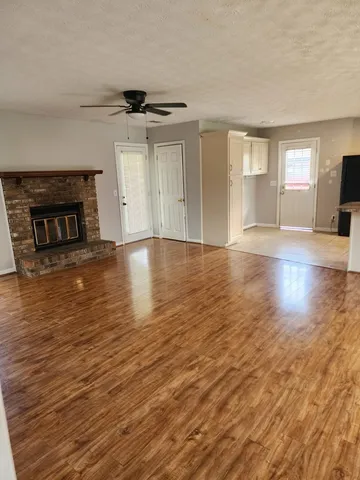 an empty room with wooden floor and fireplace