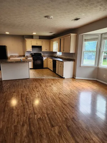 a large kitchen with stainless steel appliances granite countertop a large counter top and a stove