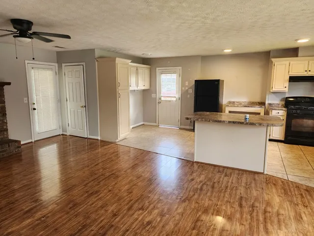 a view of kitchen with granite countertop window and wooden floor