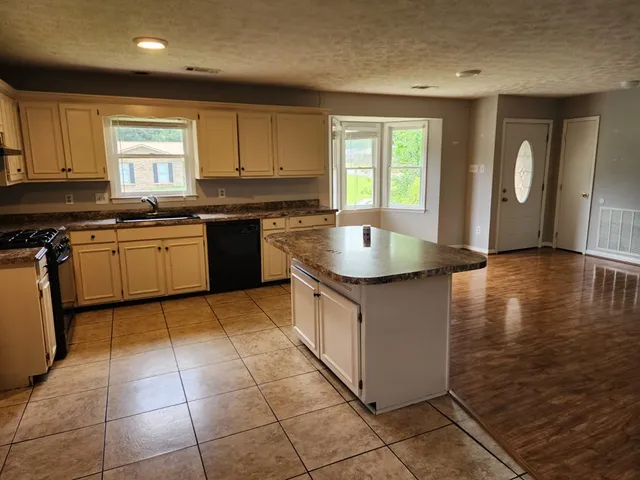 a kitchen with a sink window and cabinets