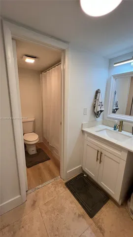 a bathroom with a sink a toilet and a mirror