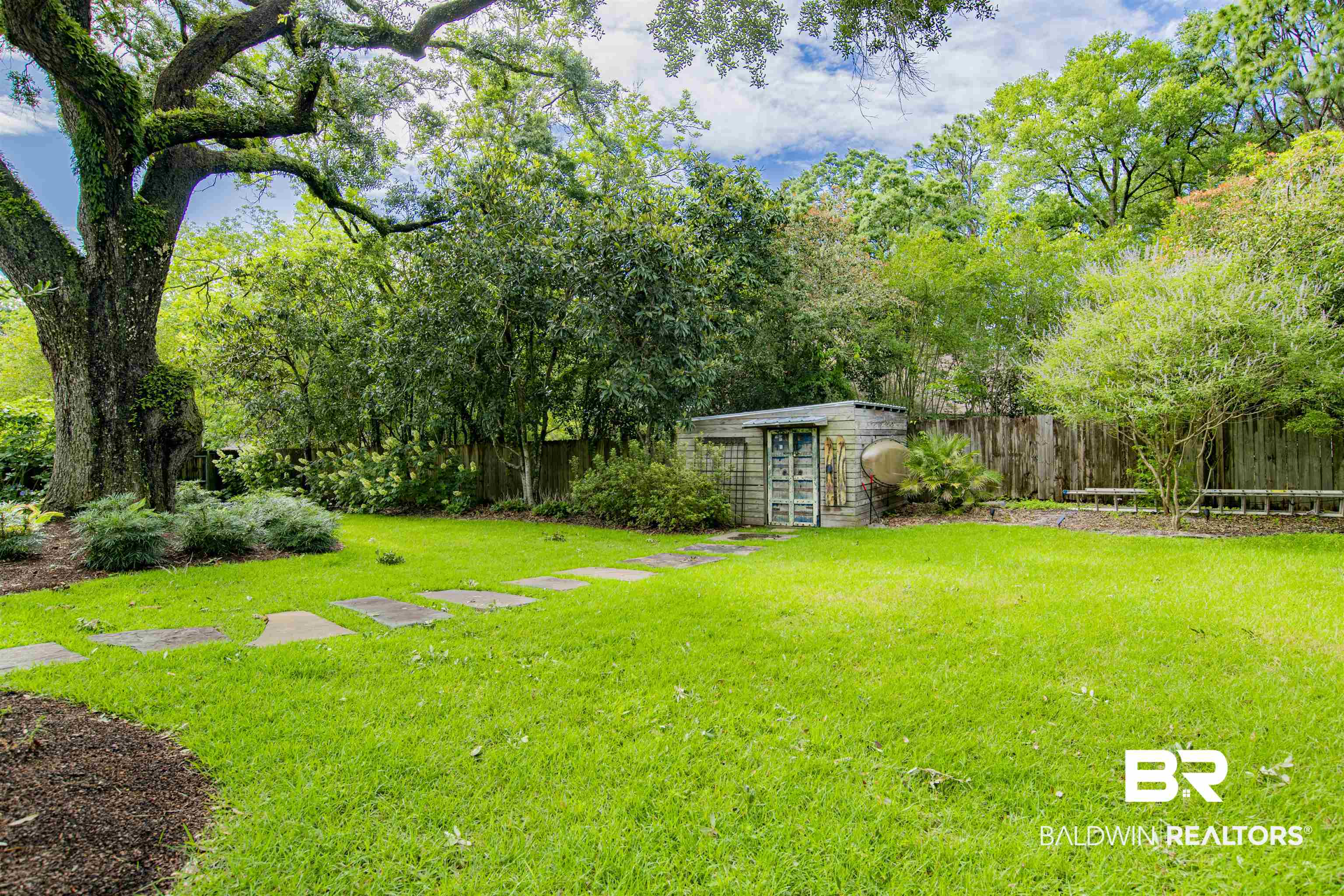 809 Bernard Circle Mobile, AL 36693 - Photo 11 of 75 Expansive green lawn with a large, mature tree featuring a stone pathway leading to a detached shed