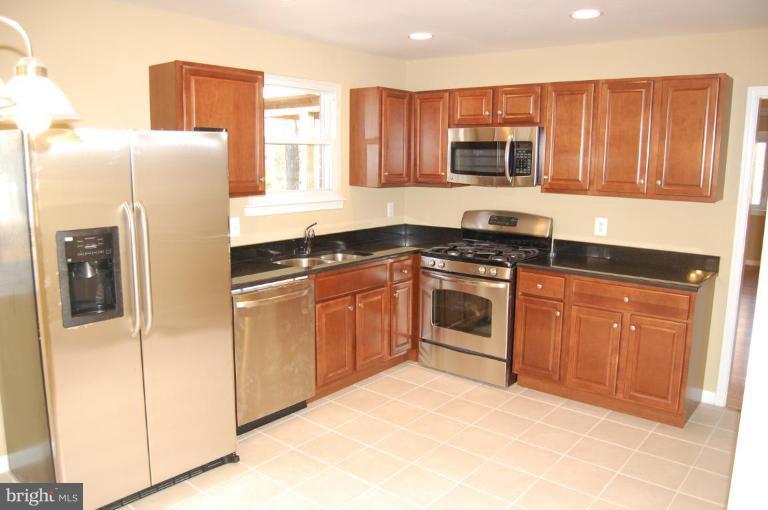 8419 Thames Street Springfield, VA 22151 - Photo 5 of 14 a kitchen with stainless steel appliances granite countertop white cabinets and refrigerator