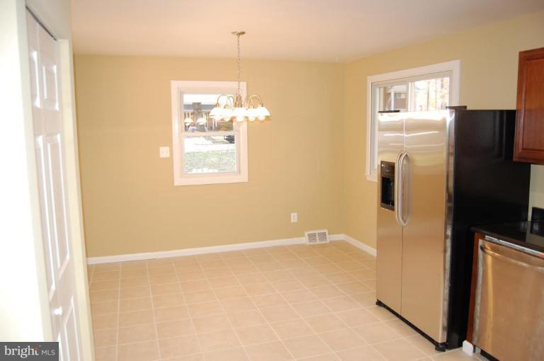 8419 Thames Street Springfield, VA 22151 - Photo 7 of 14 a view of an empty room with wooden floor and a window
