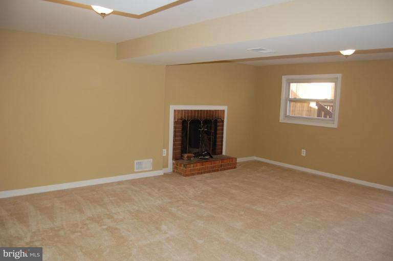 8419 Thames Street Springfield, VA 22151 - Photo 8 of 14 an empty room with a fireplace and a window