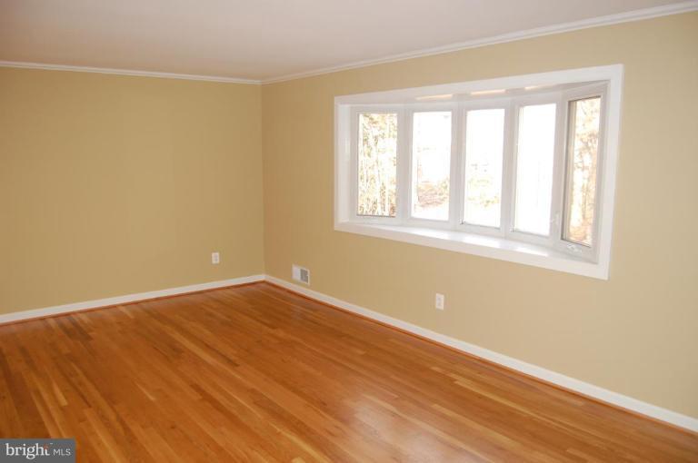8419 Thames Street Springfield, VA 22151 - Photo 10 of 14 a view of an empty room with wooden floor and a window