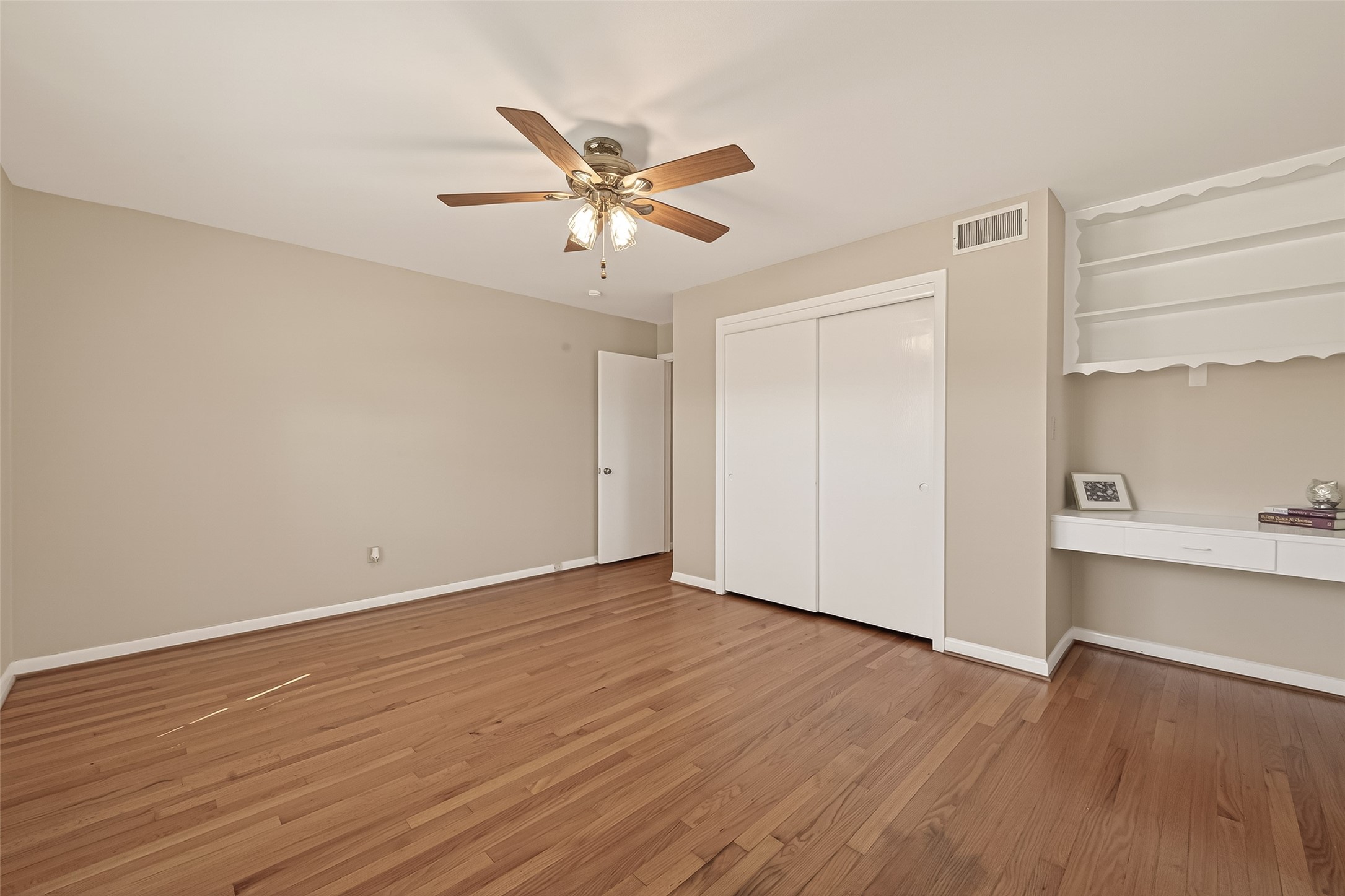 5646 Hazen Street Houston, TX 77081 - Photo 29 of 43 The secondary bedroom has built-in shelves and a desk area, ideal for a home office or vanity.