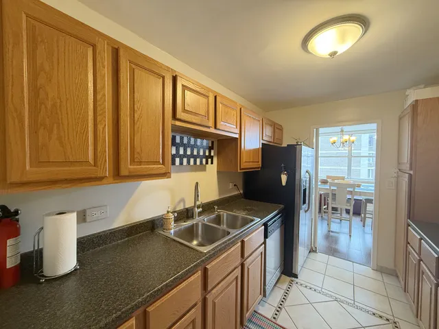 a kitchen with stainless steel appliances granite countertop a sink refrigerator and cabinets