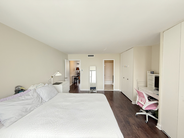 6301 North Sheridan Road, Unit 21E Chicago, IL 60660 - Photo 19 of 29 a bedroom with a bed and wooden floor