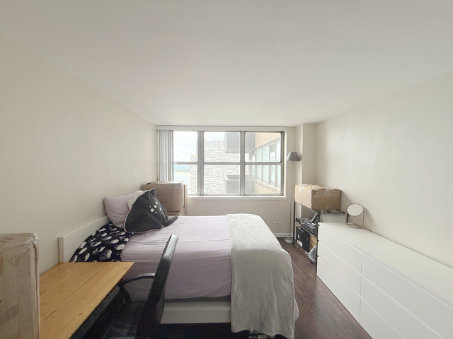 6301 North Sheridan Road, Unit 21E Chicago, IL 60660 - Photo 21 of 29 a bedroom with a bed and wooden floor