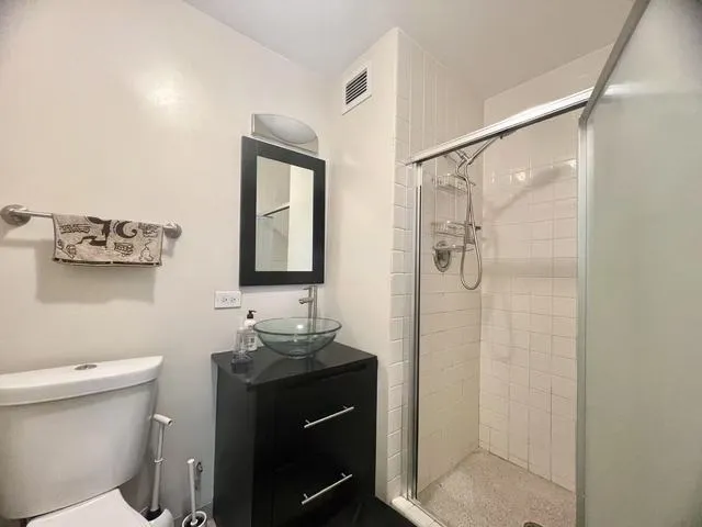 a bathroom with a granite countertop sink toilet and shower