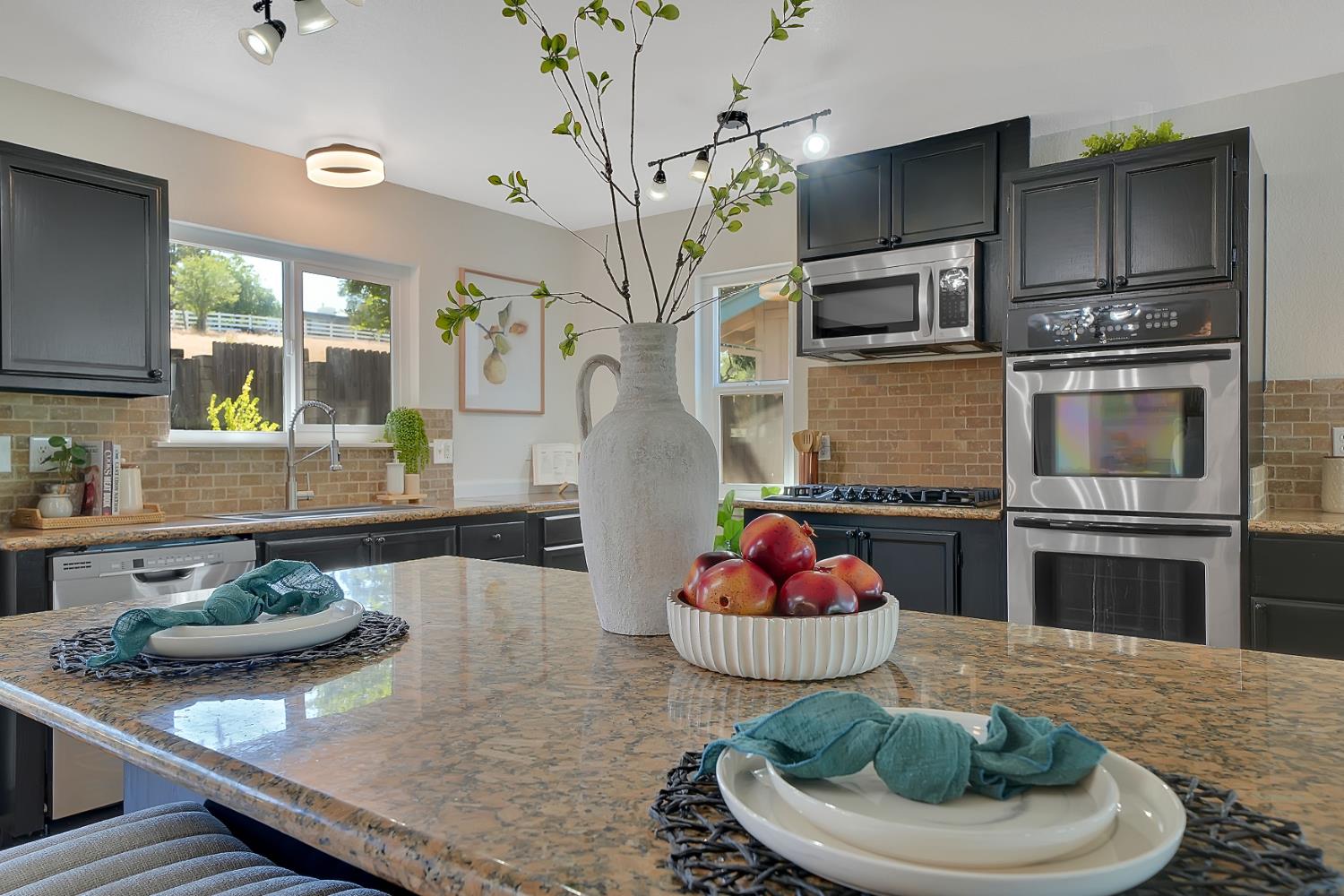 a kitchen with stainless steel appliances kitchen island granite countertop a sink and refrigerator