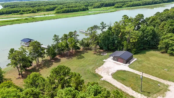 an aerial view of a house with a yard and lake view