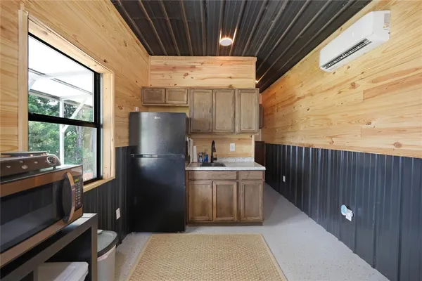 a kitchen with a sink a refrigerator and cabinets