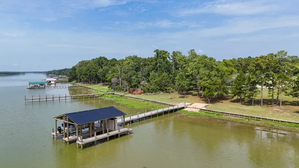 an aerial view of a house with a garden and lake view