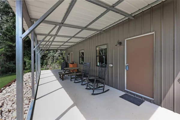 a view of swimming pool with lawn chairs and couches with wooden floor