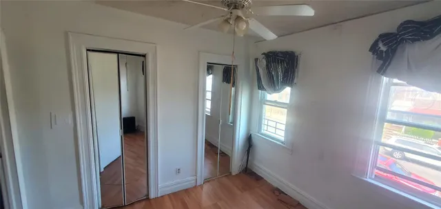 a view of a hallway with wooden floor and windows