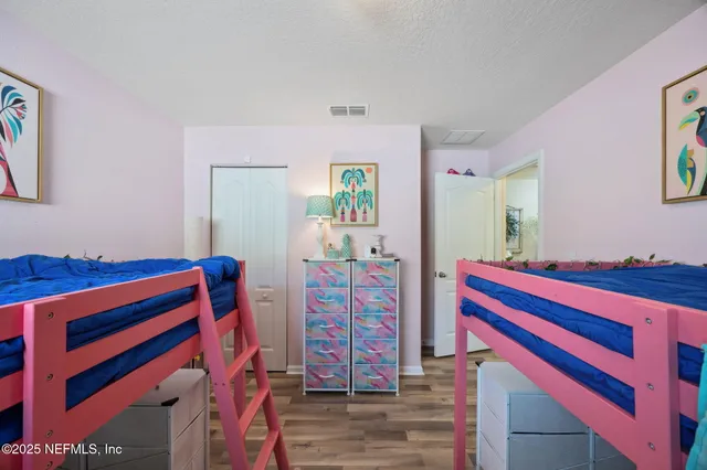 a living room with furniture a baby crib and a book shelf