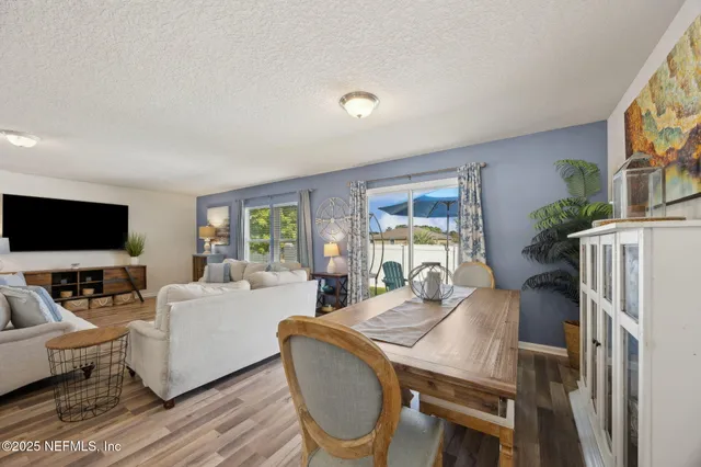 a living room with furniture a flat screen tv and a large window