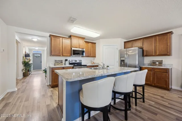 a large kitchen with kitchen island granite countertop a sink and cabinets