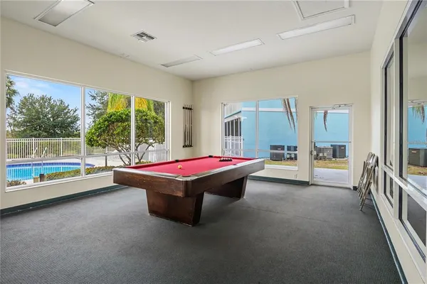 a room with pool table and glass windows
