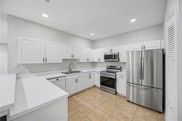 a kitchen with granite countertop stainless steel appliances and white cabinets