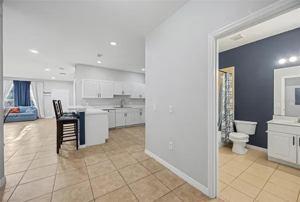 a view of a kitchen with kitchen island wooden cabinets and living room
