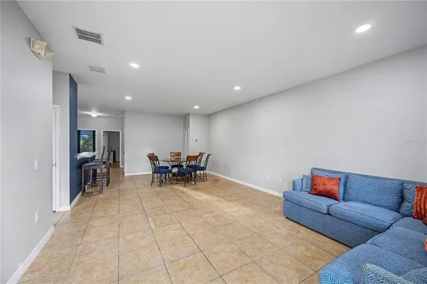 a living room with furniture and a dining table with kitchen view