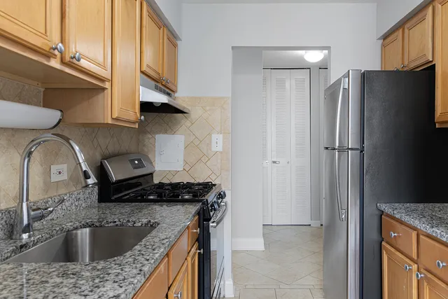 a kitchen with stainless steel appliances granite countertop a sink stove and refrigerator