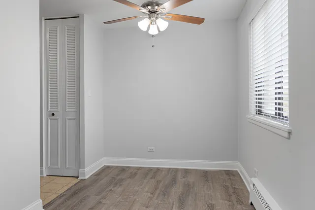 an empty room with windows and fan