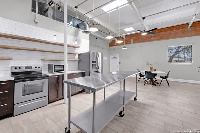 a kitchen with stainless steel appliances granite countertop a stove and a refrigerator