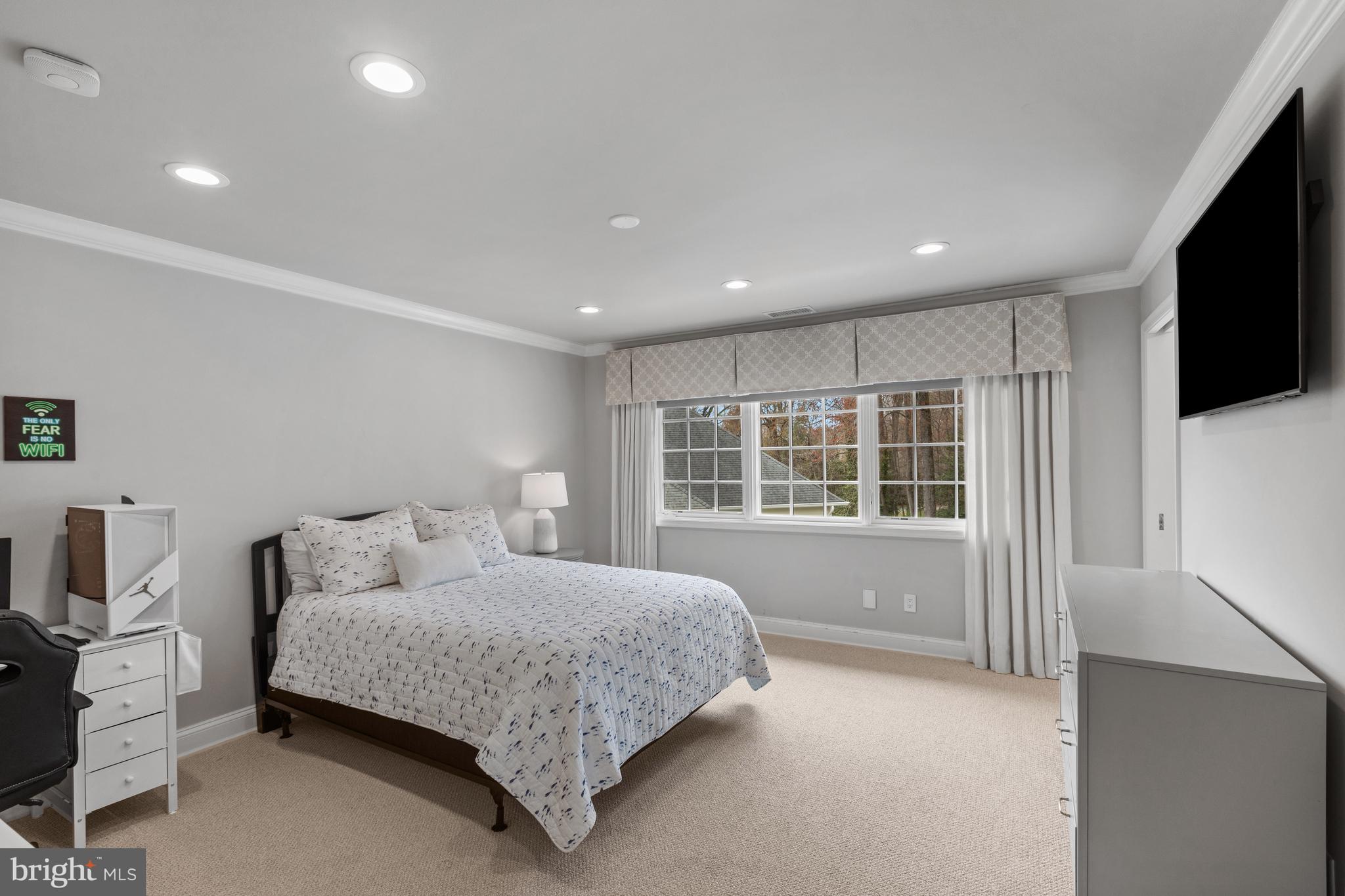 3054 Rundelac Road Annapolis, MD 21403 - Photo 32 of 49 a bedroom with a large bed and a flat tv screen on dresser