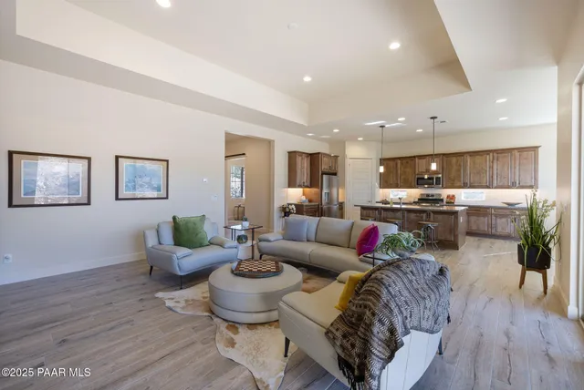 a living room with furniture kitchen and a wooden floor