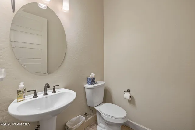 a bathroom with a toilet a sink and mirror