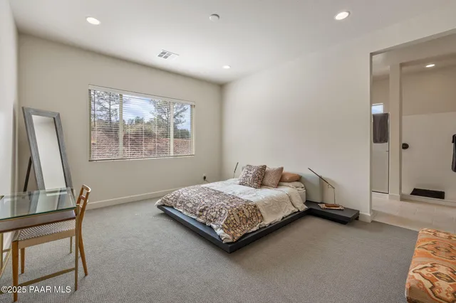 a bedroom with a bed a dresser and a window