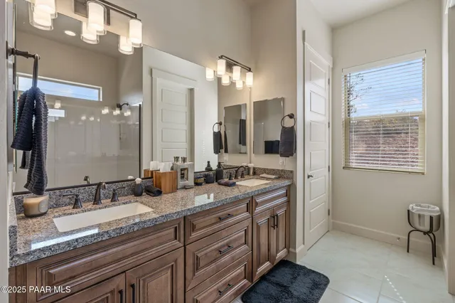 a bathroom with double sink and a mirror