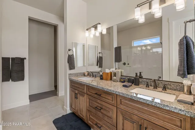a bathroom with double vanity and a mirror