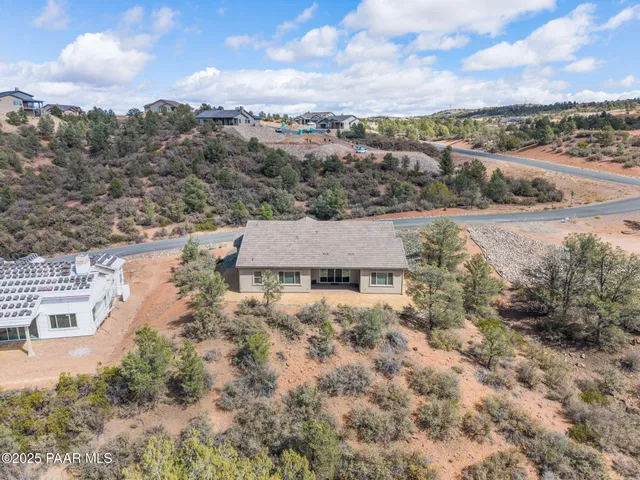 a aerial view of a house with a yard lake and mountain view in back
