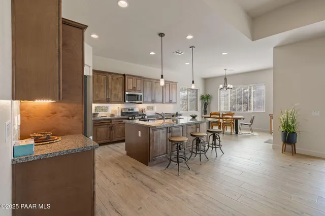 a kitchen with a table chairs refrigerator and microwave