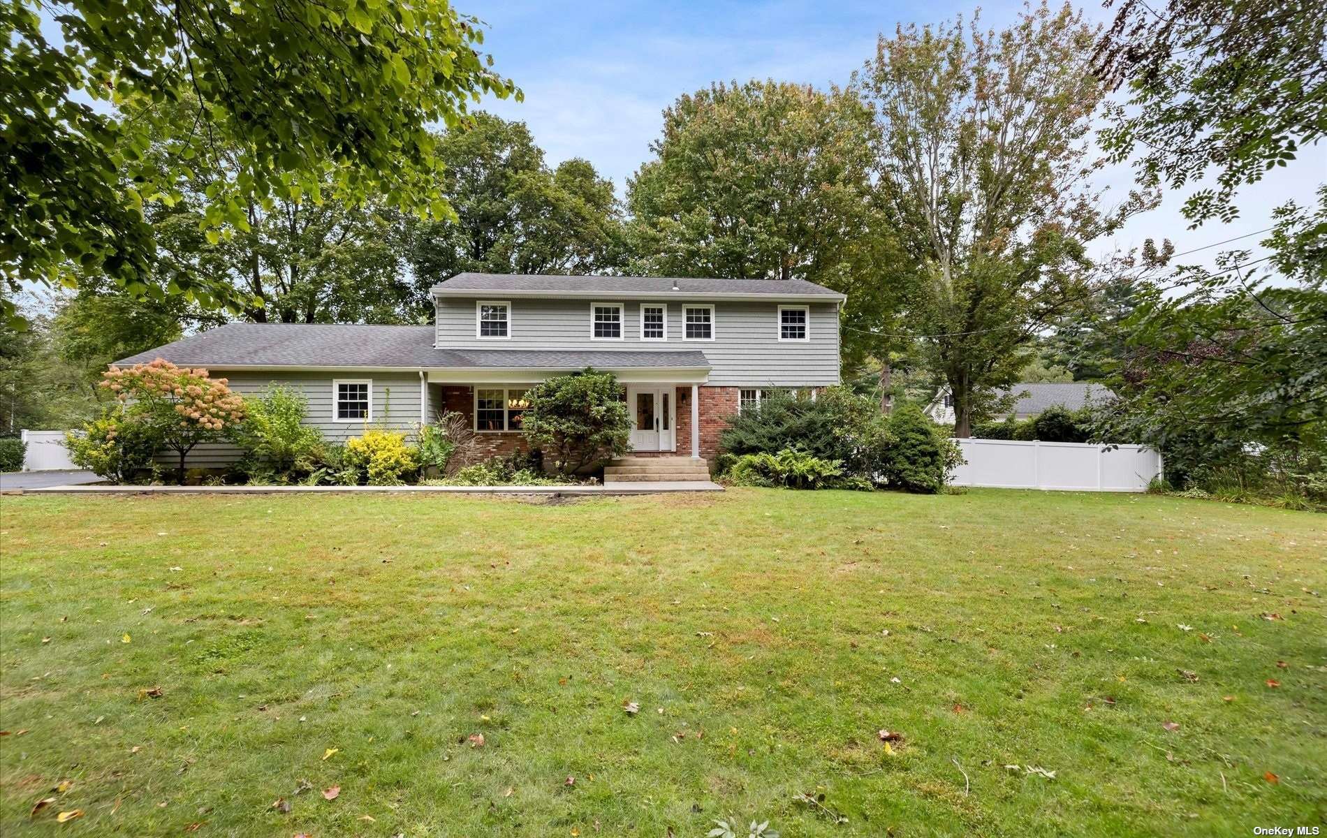 a front view of a house with yard and green space
