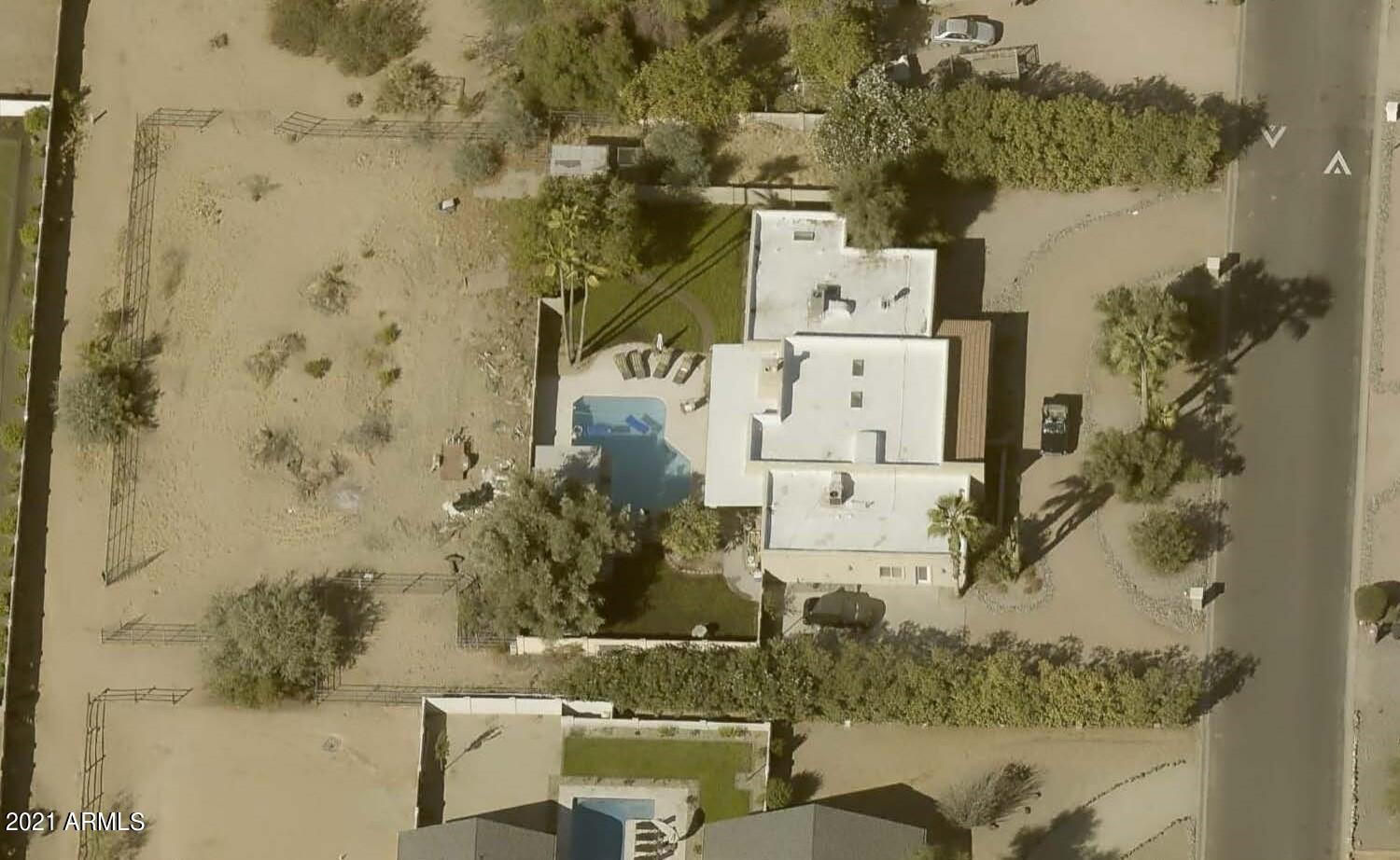 a aerial view of a house with a yard and large trees