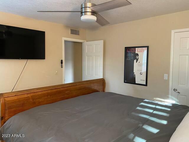 11222 North Miller Road Scottsdale, AZ 85260 - Photo 24 of 32 a bedroom with a bed and a flat screen tv