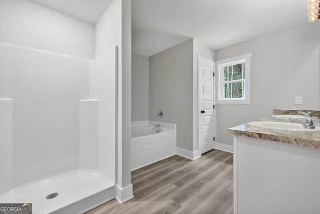 a bathroom with a granite countertop sink a bathtub and shower