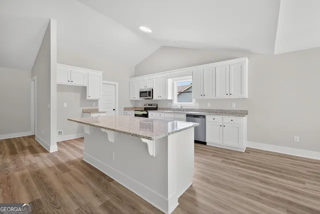 a kitchen with stainless steel appliances a sink a stove a refrigerator and cabinets