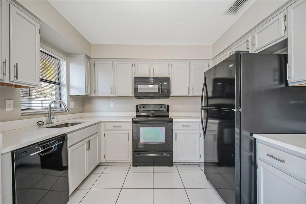 117 Pansy Court Kissimmee, FL 34743 - Photo 24 of 40 a kitchen with a sink stove and refrigerator