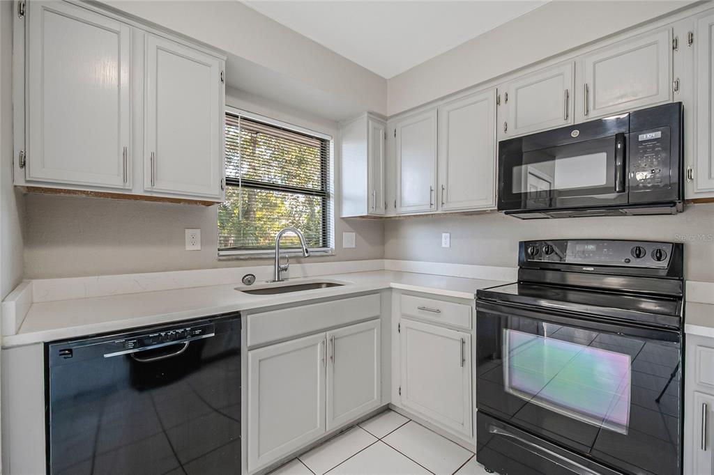 117 Pansy Court Kissimmee, FL 34743 - Photo 25 of 40 a kitchen with white cabinets appliances and a sink