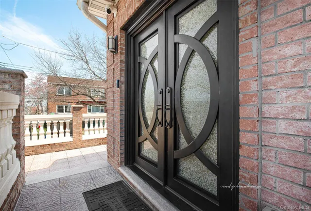a view of a brick house with wooden fence and floor to ceiling windows